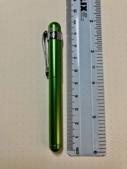 A capped green Kaweco Liliput pen next to a ruler (it's about 10cm long).